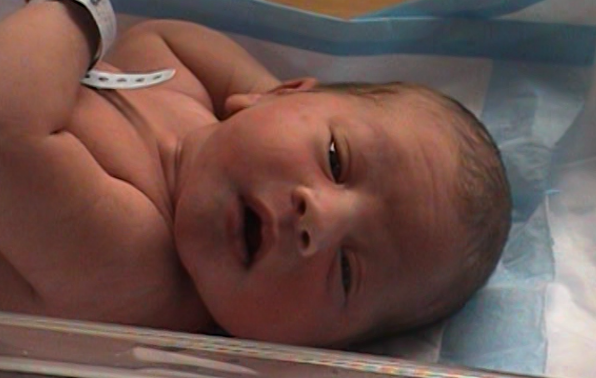 Newborn Kyser, hours into the world, already with a full head of dark hair.