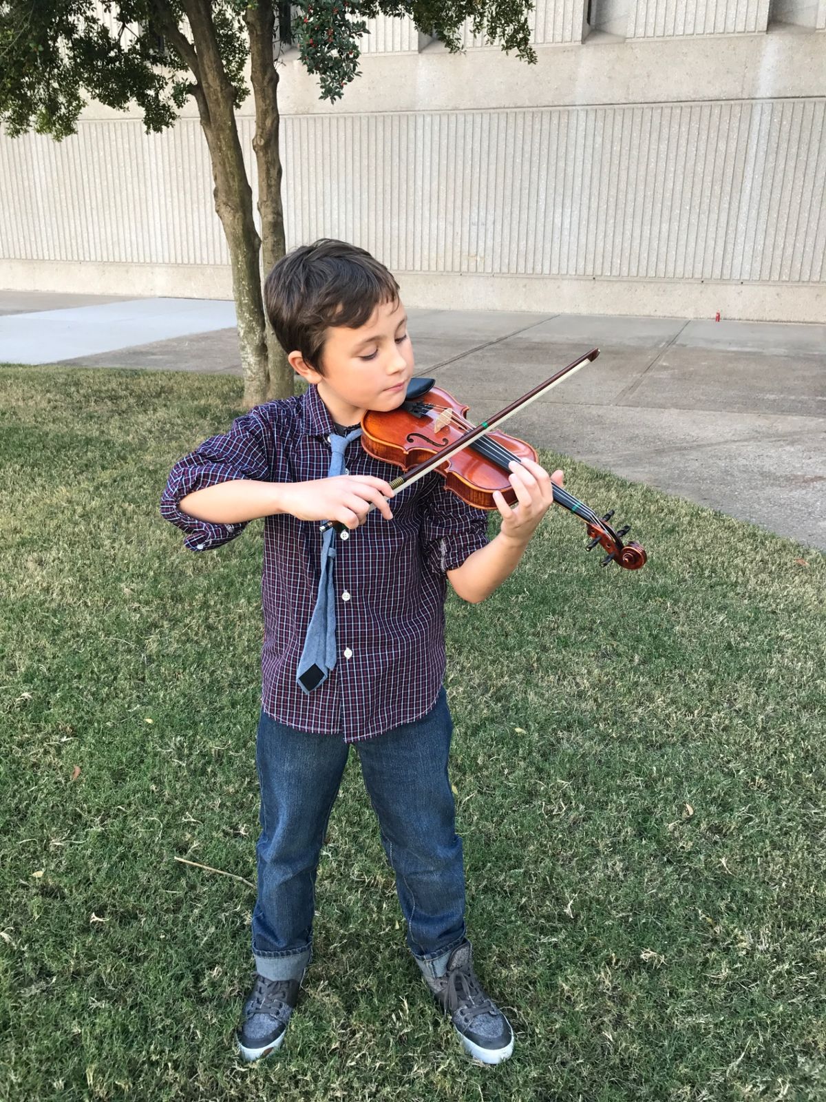 Young Kyser playing his violin at a recital, full focus.